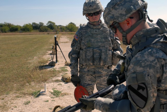 FORT HOOD, Texas - Williamsport, Penn. native, Sgt. Jeremy Lakes (left), a team leader, acts as a safety for Rockford, Ill. native, Pfc. Daniel Britton, a generator repair specialist, as he chambers a round into his shotgun at the Knob Rifle A Range,...