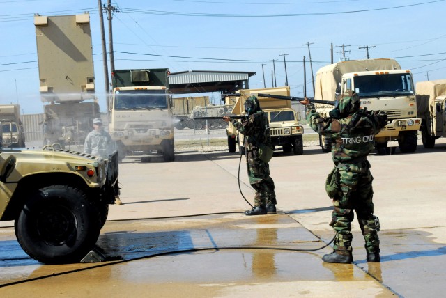 FORT HOOD, Texas - Troopers from Battery A, 26th Field Artillery Regiment, 41st Fires Brigade, remove contaminates from a humvee using a M26 generator and high powered hoses during CBRN training at the 41st Fires Bde. motor pool, Oct. 26-27....