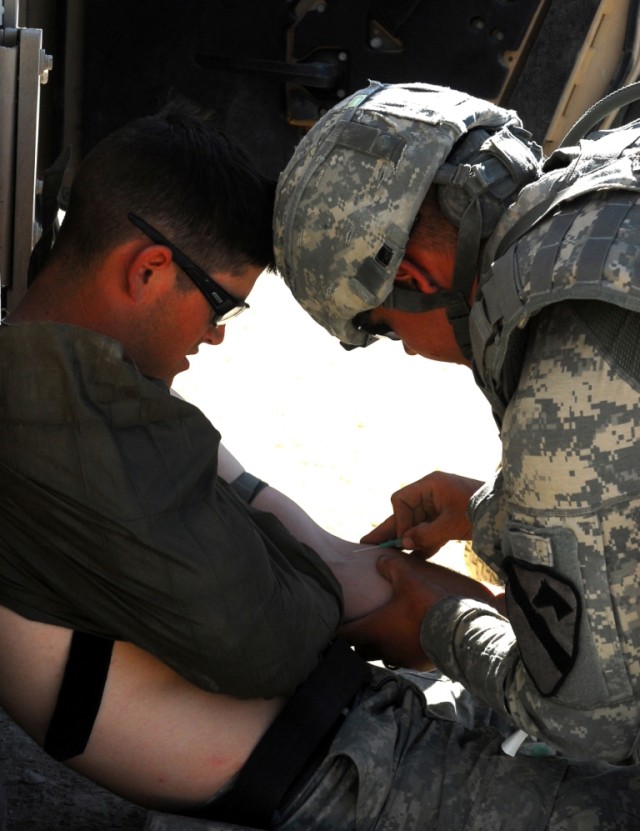 FORT HOOD, Texas- Spc. Michael Mazock (right), a medic with B Troop, 4th Squadron, 9th Cavalry Regiment, 2nd Brigade Combat Team, 1st Cavalry Division, prepares to insert a needle for an IV into Spc. Michael Fisher, a cavalry scout with Troop B,...