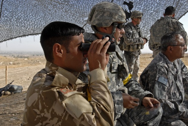 CONTINGENCY OPERATING SITE MAREZ, Iraq - Staff Sgt. Rodolfo Servin (center), a forward observer assigned to the 1st Squadron, 9th Cavalry Regiment, 4th Advise and Assist Brigade, 1st Cavalry Division, talks an Iraqi Army Soldier through the steps of ...