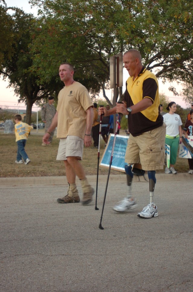 FORT HOOD, Texas - Lt. Col. Jack Usrey (left) walks the last 100 steps of his 100-mile trek with Lt. Col. Tim Karcher near the 1st Cavalry Division Headquarters, Oct. 29. Karcher lost both legs above the knees when his MRAP was struck by an IED...