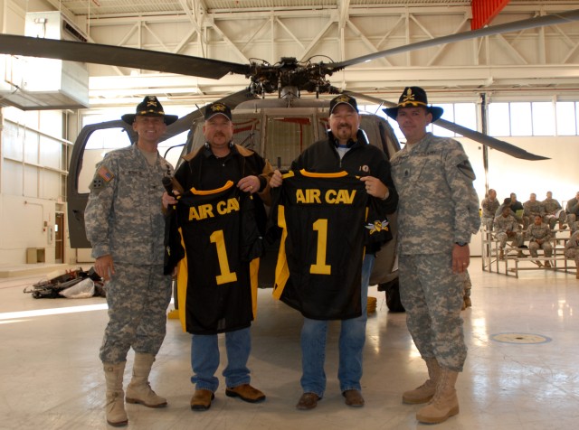 FORT HOOD, Texas - Col. John Novalis (far left), of Williamsport, Penn., commander, 1st Air Cavalry Brigade, 1st Cavalry Division, and Command Sgt. Maj. Vela (far right), give football jerseys to Zach Owen and Jim Cody. The two radio personalities...