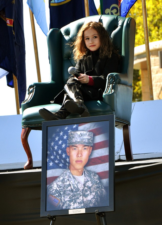 FORT HOOD, Texas-Rhema Marvanne, of Carrollton, Texas, sits above the picture of Pfc. Kham Xiong, a Soldier who lost his life in the Nov. 5, 2009 shootings on Fort Hood. Rhema sang the song "The Prayer," at the Remembrance Memorial Ceremony outside o...