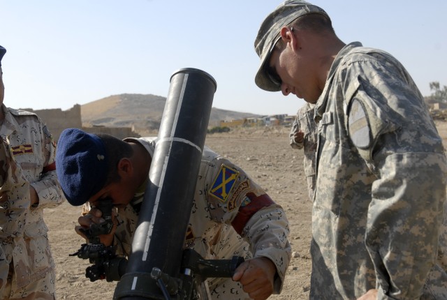 CONTINGENCY OPERATING SITE MAREZ, Iraq-Spc. Scott David, a gunner assigned to the 1st Squadron, 9th Cavalry Regiment, 4th Advise and Assist Brigade, 1st Cavalry Division, assists an Iraqi Army Soldier assigned to the 6th Brigade, 3rd Division,...