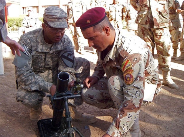 CONTINGENCY OPERATING SITE MAREZ, Iraq-Sgt. Andrew Harris (left), a squad leader from the mortar platoon of the 2nd Battalion, 7th Cavalry Regiment, 4th Advise and Assist Brigade, 1st Cavalry Division, teaches a 60-mm mortar familiarization class...