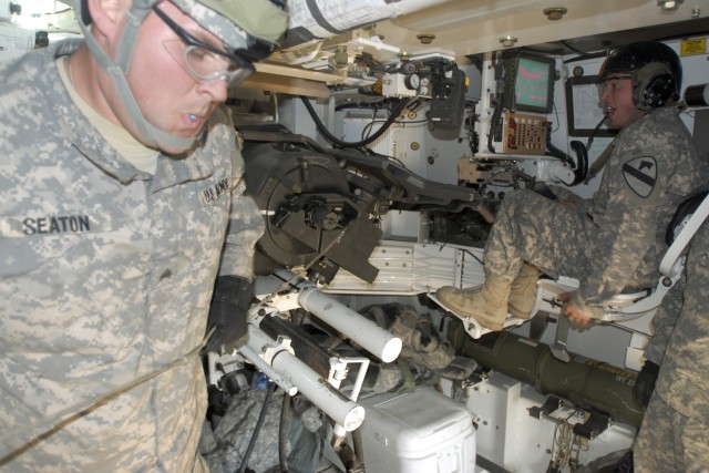 FORT IRWIN, Calif. - Sgt. Justin Seaton(left), a canon crewmember with 2nd Battalion., 82nd Field Artillery Regiment, 3rd Brigade Combat Team, 1st Cavalry Division, pulls the lanyard to fire a 155 millimeter artillery round during a live fire...