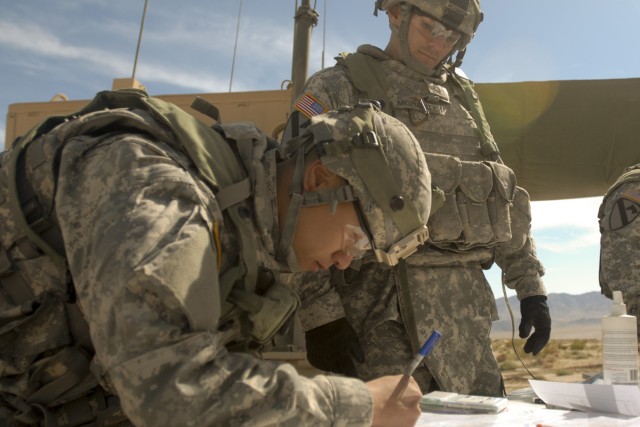 FORT IRWIN, Calif. - 2nd Lt. Brian Lee (left), a fire direction officer, and Sgt. 1st Class Shawn "Smoke" Moriarity, a platoon sergeant, both with 2nd Battalion., 82nd Field Artillery Regiment, 3rd Brigade Combat Team, 1st Cavalry Division, plot...