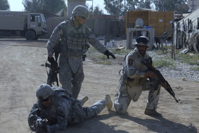 JOINT SECURITY STATION INDIA, Iraq- Spc. Michael Malone, an infantryman assigned to 2nd Battalion, 7th Cavalry Regiment, 4th Advise and Assist Brigade, 1st Cavalry Division, instructs an Iraqi Soldier in how to properly pull security at a combined...