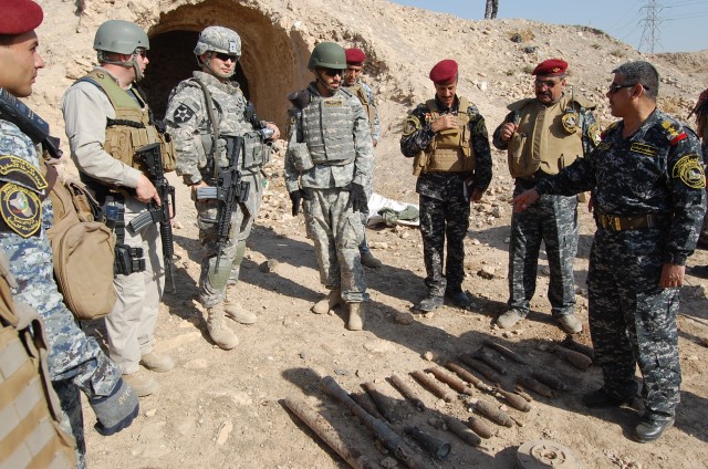 CONTINGENCY OPERATING SITE MAREZ, Iraq -Iraqi Federal Police in Mosul display explosives found during a cordon and search mission to Soldiers assigned to Task Force Spear, 4th Advise and Assist Brigade, 1st Cavalry Division, Nov. 11. The U.S. Soldier...