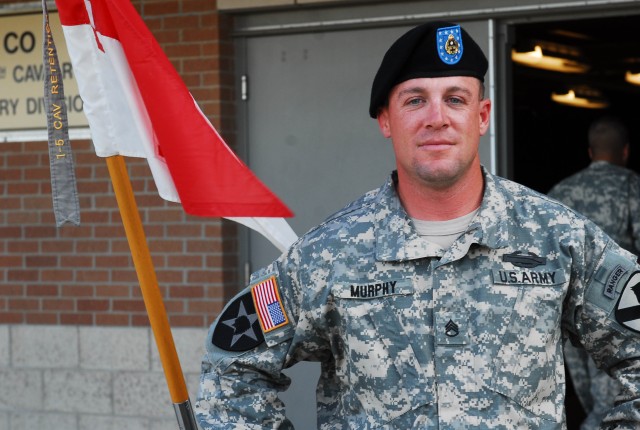 FORT HOOD, Texas- Staff Sgt. Jamey Murphy, from Jonestown, Pa., an infantryman with B Company, 1st Battalion, 5th Cavalry Regiment, 2nd Brigade Combat Team, 1st Cavalry Division, stands next to his company guidon on Fort Hood, Texas, Nov. 10, proudly...