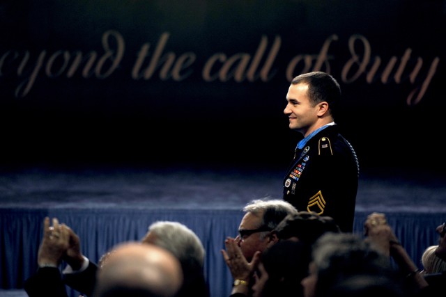 Medal of Honor recipient Army Staff Sgt. Salvatore Giunta looks over at his team members from Company B, 2nd Battalion, Airborne, 503rd Infantry Regiment, as they stand to be recognized during Giunta's induction ceremony into the Hall of Heroes at th...