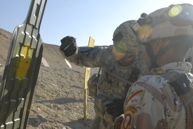 JOINT SECURITY STATION INDIA, Iraq-Pfc. Sam Forsyth (left), a sniper assigned to Headquarters and Headquarters Company, 2nd Battalion, 7th Cavalry Regiment, 4th Advise and Assist Brigade, 1st Cavalry Division, marks his Iraqi counterpart's shot...