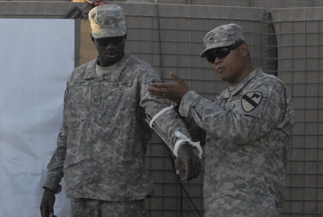 Sgt. Benjamin Jingco (right), a combat medic assigned to 2nd Battalion, 7th Cavalry Regiment, 4th Advise and Assist Brigade, 1st Cavalry Division, demonstrates on Pfc. Myron Macklin, from Petersburg, Va., how to properly splint a fractured arm at...