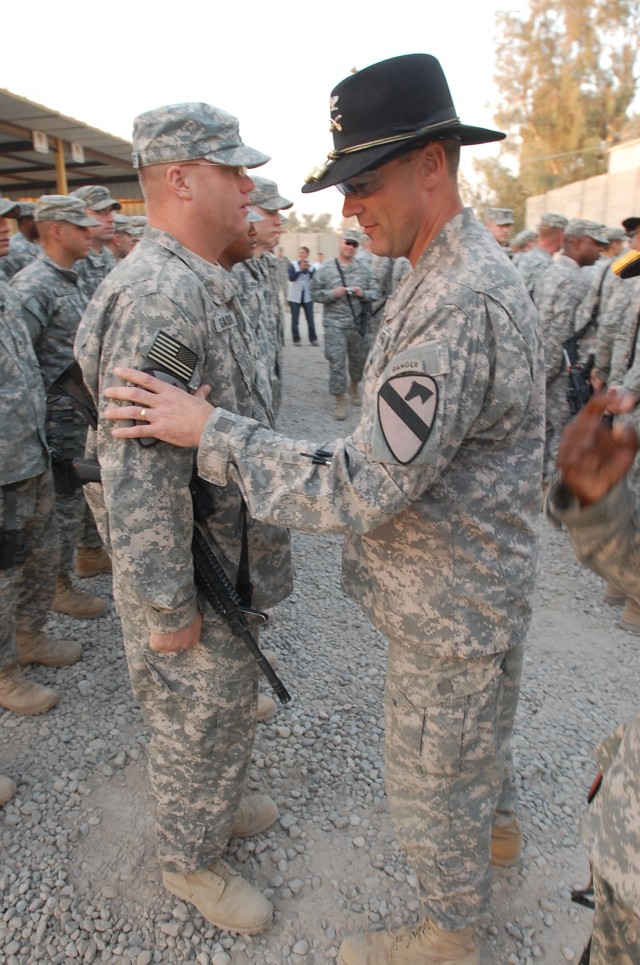 CONTINGENCY OPERATING BASE MAREZ, Iraq-Col. Brian Winski (right), commander of the 4th Advise and Assist Brigade, 1st Cavalry Division, places the distinctive "First Team" patch on the sleeve of a Soldier during the unit's combat patch ceremony on...