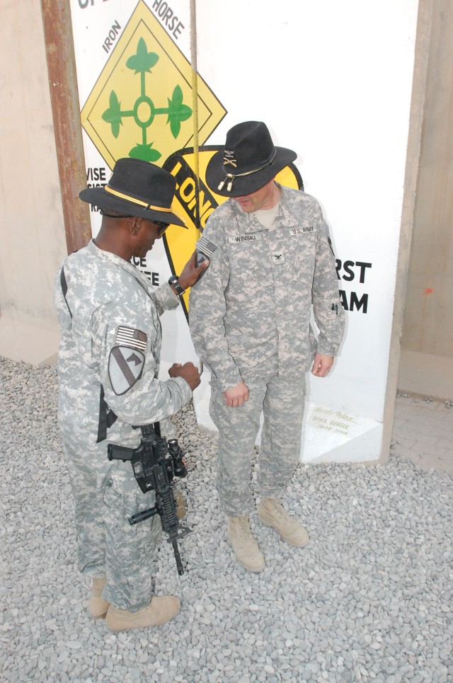 CONTINGENCY OPERATING BASE MAREZ, Iraq-Command Sgt. Maj. Antoine Overstreet (left), the command sergeant major for the 4th Advise and Assist Brigade, 1st Cavalry Division, places the division's patch on Col. Brian Winski, commander of the 4th AAB, du...