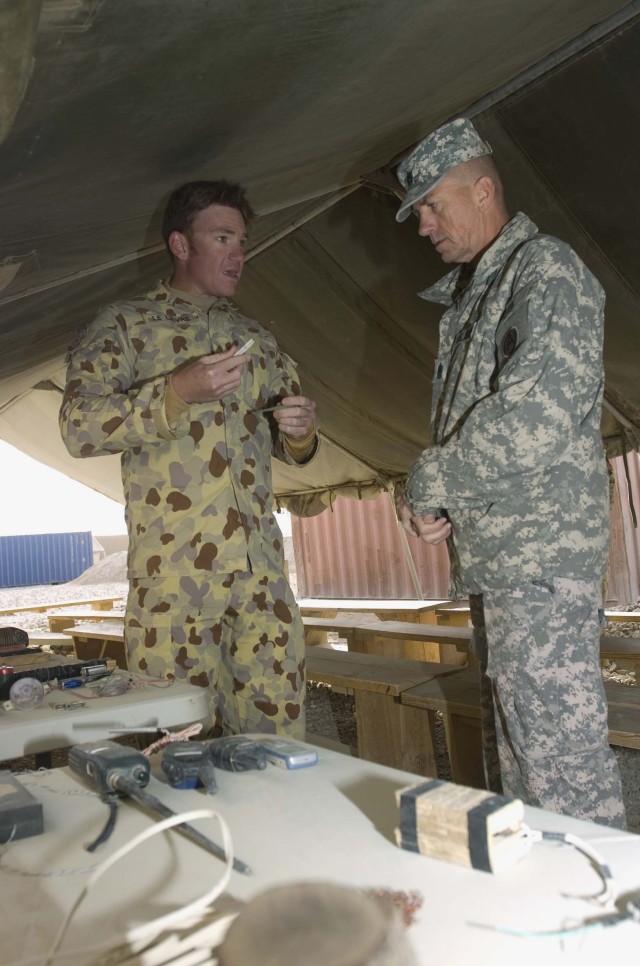 KANDAHAR AIRFIELD, Afghanistan - Command Sgt. Maj. John D. Fourhman, Third Army command sergeant major (right), speaks with Australian Army Sgt. Alistair Lievre, Regional Command - South's counter-IED range officer in command with NATO's Internationa...