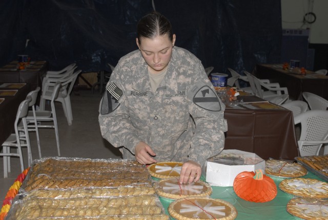 JOINT SECURITY STATION INDIA, Iraq-Pfc. Amber Perrine, a cook assigned to E Forward Support Company, 2nd Battalion, 7th Cavalry Regiment, 4th Advise and Assist Brigade, 1st Cavalry Division, sets up the dessert table Nov. 25. Perrine, a native of...