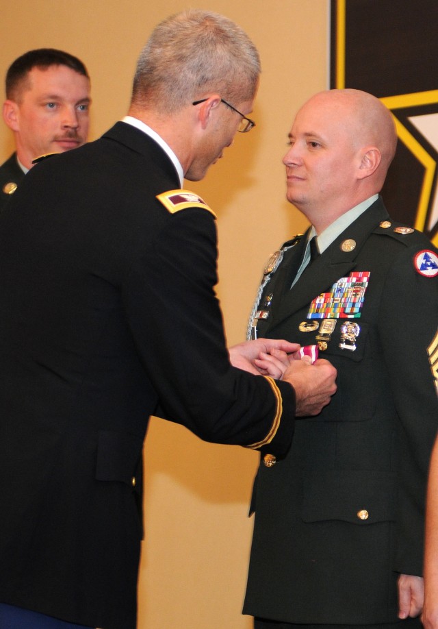 Colonel Ronald Place, the Fort Knox Medical Department Activity commander, pins the Meritorious Service Medal on Sgt. 1st Class Charles Hibbs, a paralegal noncommissioned officer with the 3d Sustainment Command (Expeditionary), during his retirement ...