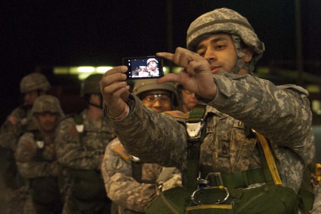 A paratrooper takes a picture with his cell during Operation Toy Drop