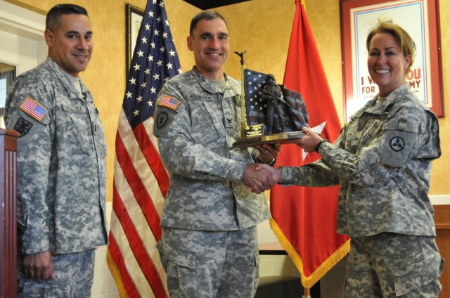 (Left to right) Command Sgt. Maj. Tony Escalona and Col. Lawrence Kominiak, the 7th Sustainment Brigade command sergeant major and commander, respectively, receive the 3rd Sustainment Command (Expeditionary) Top Sustainer award from Brig. Gen....