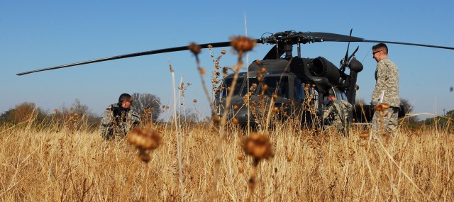 FORT HOOD, Texas - Chief Warrant Officer 2 Gabe Gomez (left), from Alvin, Texas, a UH-60 Blackhawk helicopter pilot for Company C, Task Force Spear Head, 1st Air Cavalry Brigade, 1st Cavalry Division, pulls security outside a simulated downed...