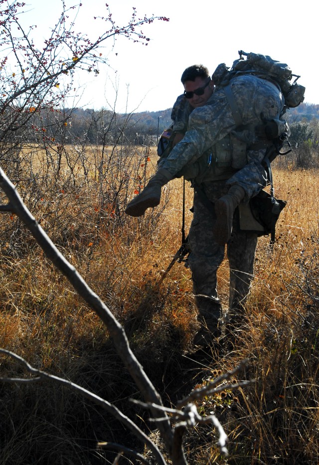 FORT HOOD, Texas - Spc. Robert Williams, a native of Oklahoma City, a Blackhawk crew chief in Company C, Task Force Spear Head, 1st Air Cavalry Brigade, 1st Cavalry Division, carries a simulated injured Soldier to an extraction point for medical...