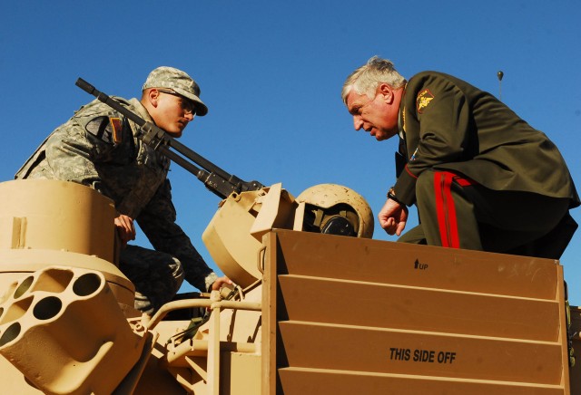 FORT HOOD, Texas- Sgt. Travis Pelz (left), an Angola, N.Y. native and a master gunner with 1st Battalion, 8th Cavalry Regiment, 2nd Brigade Combat Team, 1st Cavalry Division, shows Col. Gen. Alexander Postnikov, the Commander-in-Chief Land Forces...