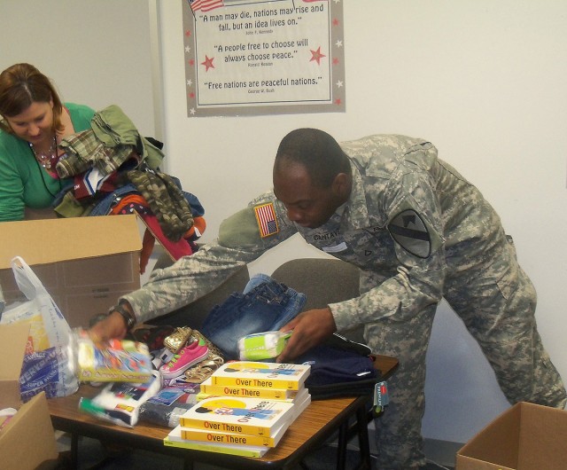 Pfc. Renel Cantave, an intel analyst with Headquarters Company, Task Force Guns, 1st Air Cavalry Brigade, 1st Cavalry Division, sorts through needed supplies that were donated by Soldiers and family members of the task force to the students of Trimmi...