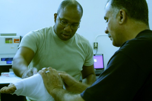 CONTINGENCY OPERATING SITE MAREZ, Iraq- Staff Sgt. Willie Gray (left), a native of Greenville, S. C., shows Hussin Ali, a medic with the Iraqi 3rd Federal Police Division, how to wrap a foot for casting to immobilize an injury, Dec. 20.  Gray, a medi...