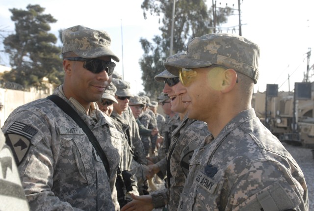 JOINT SECURITY STATION INDIA, Iraq-Spc. Gabriel Smith (left), congratulates Pfc. Dustin Sutherland, a welder and native of Buckhead, N.C., during an awards ceremony at Joint Security Station Iraqi Media Network Dec. 23. Sutherland received a...