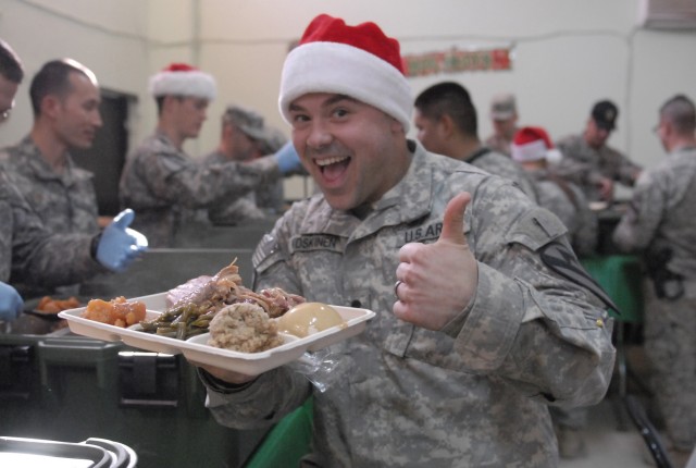 JOINT SECURITY STATION INDIA, Iraq-Spc. John Koskinen, a tanker assigned to Headquarters and Headquarters Company, 2nd Battalion, 7th Cavalry Regiment,  4th Advise and Assist Brigade, 1st Cavalry Division, shows off his Christmas dinner Dec. 25. Sold...