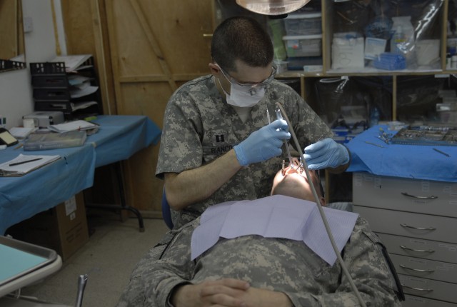 COTINGENCY OPERATING SITE MAREZ, Iraq - Capt. Bernardo Bianco, a dentist assigned to Company C, 27th Brigade Support Battalion, 4th Advise and Assist Brigade, 1st Cavalry Division, seals a filling at the troop medical clinic for 1st Lt. Frank Siler D...