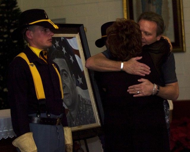 Phil Taylor, artist for and founder of The American Fallen Soldiers Project: Portraits of Patriotism, embraces Shirley Chitjian, wife of Cpl. Adam Chitjian, 3rd Battalion, 8th Cavalry Regiment, 3rd Brigade Combat Team, 1st Cavalry Division, who was k...