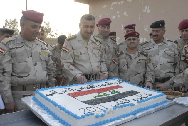 CONTINGENCY OPERATING SITE MAREZ, Iraq - Staff Col. Mohamed 'Olwan (center), commander of 1st Battalion, 11th Brigade, 3rd Iraqi Army Division, cuts the first slice of cake during a ceremony commemorating the 90th Anniversary of the Iraqi Army at al-...