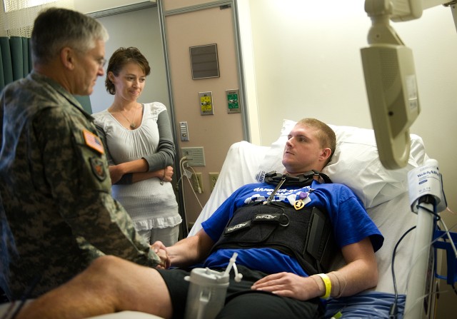 Chief of Staff of the US Army, Gen. George W. Casey Jr.,  shakes the hands with Spc. Logan Hawthorn after presenting him with a Purple Heart Medal at Brooks Army Medical Center in Ft. Sam Houston, TX, on Jan. 21, 2011.  Hawthorn was wounded by an...