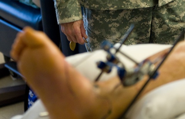 Chief of Staff of the US Army, Gen. George W. Casey Jr.,  prepares a Purple Heart medal for its presentation to Spc. Logan Hawthorn at Brooks Army Medical Center in Ft. Sam Houston, TX, on Jan. 21, 2011.  Hawthorn was wounded by an improvise...