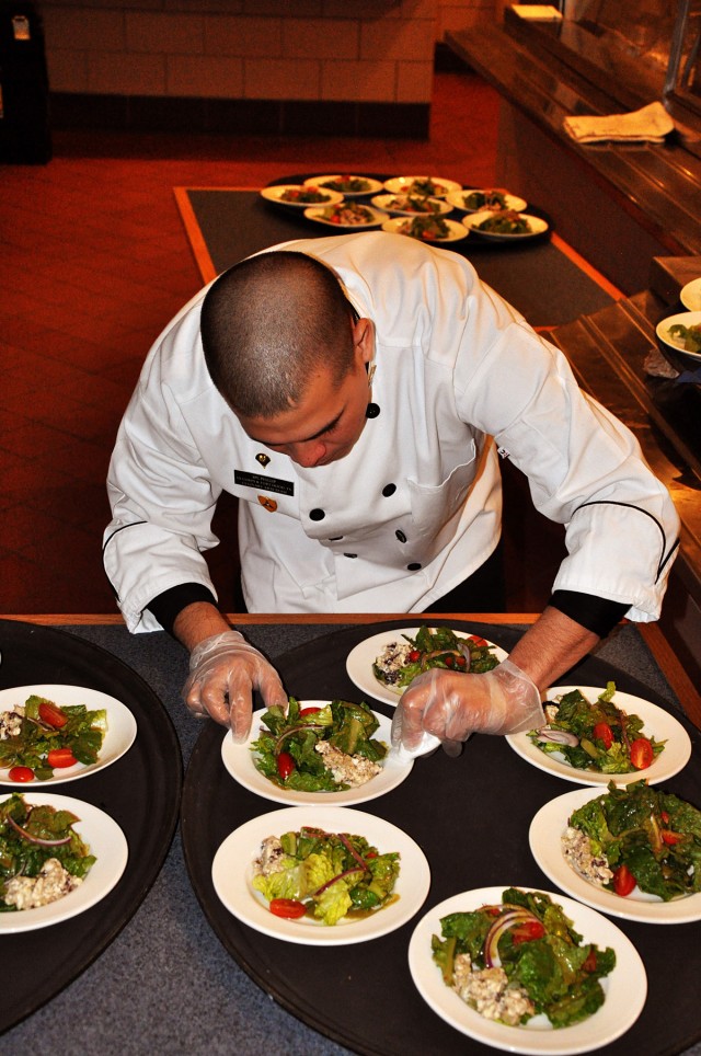 FORT HOOD, Texas-Spc. John-Paul Phillips, centerpiece specialist with Team Hood Culinary Arts Team, prepares the house salad tossed with vinaigrette dressing at the luncheon held for the command teams and the senior enlisted members of the 41st Fires...