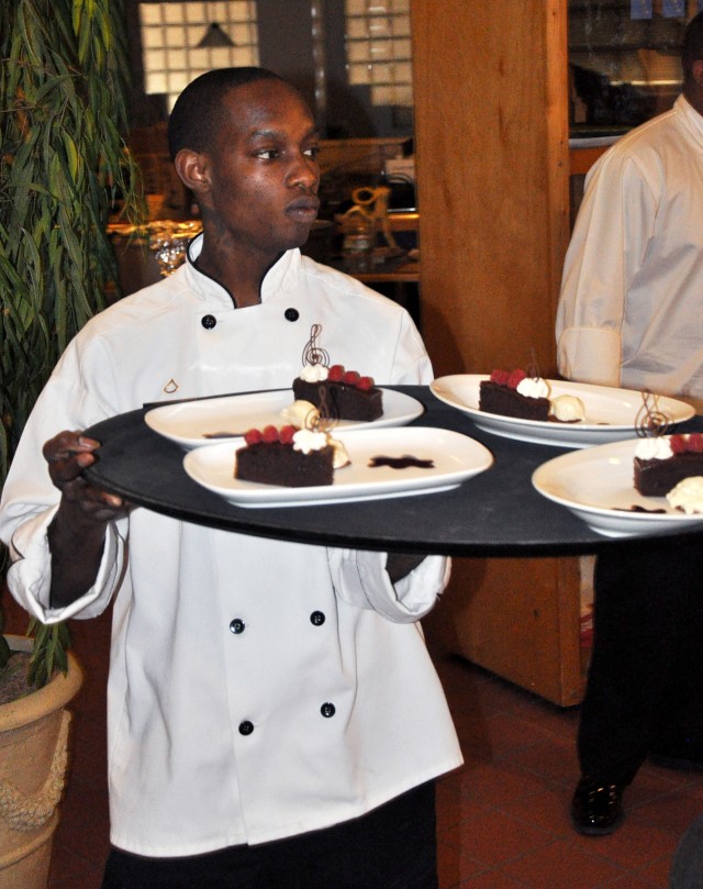 FORT HOOD, Texas-Pfc. Delano Taylor, a Chicago native, a Team Hood junior chef from 2nd Battalion, 20th Field Artillery Regiment, carries out the dessert tray of chocolate cake covered with a blackberry sauce and a scoop of vanilla ice cream...