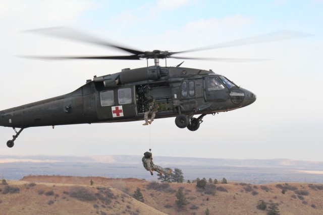 FORT CARSON, Colo.-Staff Sgt. Chad Farris (top), of Salisbury, N.C., a UH-60A Black Hawk helicopter crew chief, operates the hoist while Staff Sgt. Alexis Marulanda, of Piscataway, N.J., a flight medic, is lowered to the ground during rescue hoist...