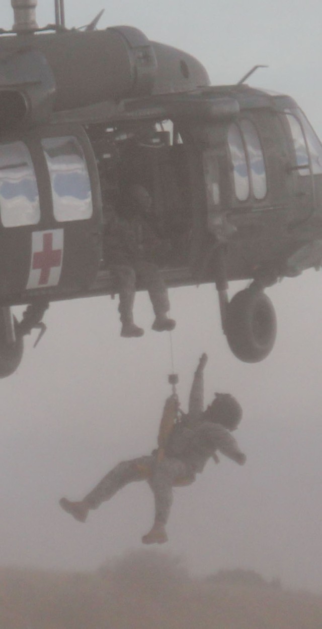 FORT CARSON, Colo.-Staff Sgt. Chad Farris, of Salisbury, N.C., a UH-60A Black Hawk helicopter crew chief, Company C, Task Force Attack, 1st Air Cavalry Brigade, 1st Cavalry Division, operates the hoist while Staff Sgt. Alexis Marulanda, of...