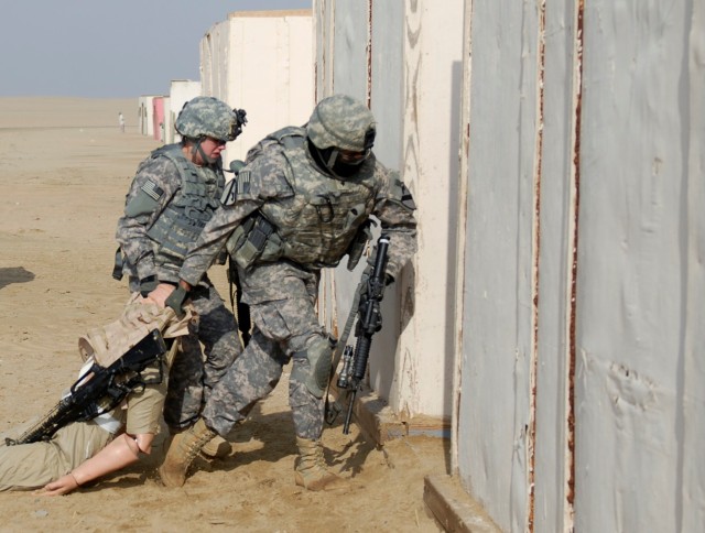 CAMP BUEHRING, Kuwait - Pvt. Shelby Bandy (left) and Spc. Bryen Reid, both with the personal security detachment, Headquarters and Headquarters Troop, 3rd Advise and Assist Brigade, 1st Cavalry Division, move a casualty to a secure location during...