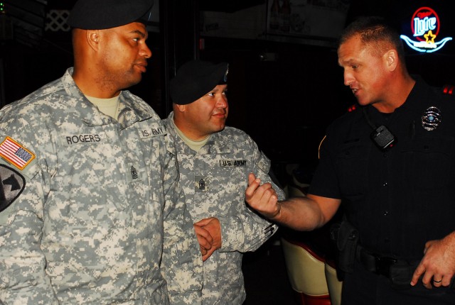 FORT HOOD, Texas - Officer Jay Leach (right), from the Harker Heights Police Department, talks with Walter Rogers (left) and Ernest Villanueva, both first sergeants with 2nd Brigade Combat Team, 1st Cavalry Division, during a courtesy patrol in Harke...