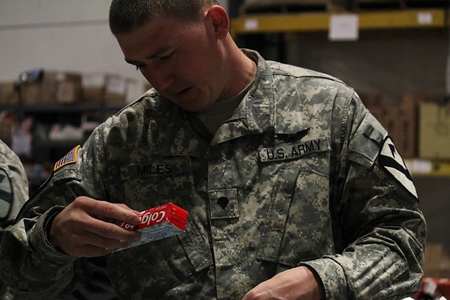 FORT HOOD, Texas--Spc. Justin Miles, a motor transport operator with Headquarters Company, Task Force Lobos, 1st Air Cavalry Brigade, 1st Cavalry Division, makes a care package for deployed troops Feb. 10 at the Soldiers' Angels headquarters in...