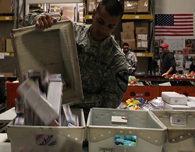 FORT HOOD, Texas-Spc. Miguel Balladeres, originally from San Diego, empties a box of toothpaste bottles onto the assembly line so that they can be put in care packages for deployed troops Feb. 10 at the Soldiers' Angels headquarters in San...