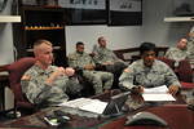 Sergeant Maj. Andrea Maine, (right) operations sergeant major, and Maj. Chris Johnson, (left) operations officer in charge, 7th Sustainment Brigade discuss pending critical tasks with their staff during the plans and operations weekly meeting Feb. 17...