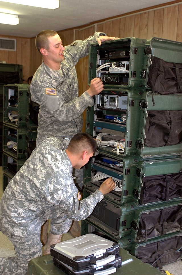 FORT HOOD, Texas-Spc. Daniel Westwood (standing), from Spanish Fort, Ala., and Spc. Nicholas Borrego, of Lamesa, Texas, both multi-channel transmissions system operator/maintainers for 41st Fires Bde., operate the command post node during the...