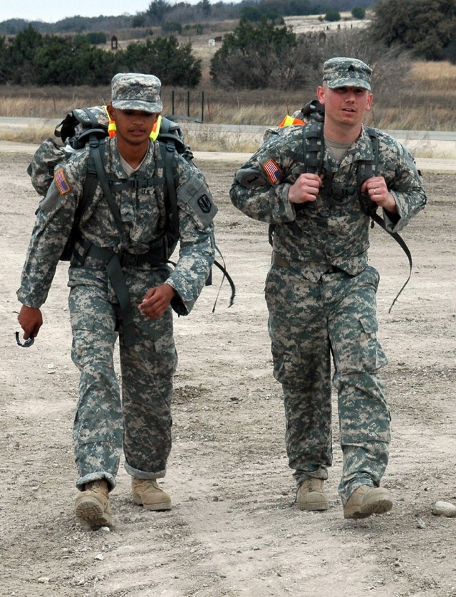 FORT HOOD, Texas-Pvt. Rolando Manilili (left), from Yigo, Guam, and Sgt. Nathan McElroy, from Gainesville, Fla., finish their 22 mile ruck march on the tank trail Feb. 23. Ten Rail Gunner Soldiers are practicing for the 22nd annual Bataan Memorial...