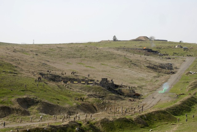 CONTINGENCY OPERATING SITE MAREZ, Iraq - Green smoke signals a secured objective as Iraqi soldiers maneuver and fire to defeat enemy threats during a battalion-sized live fire exercise at Ghuzlani Warrior Training Center, Feb. 24, 2011. The...