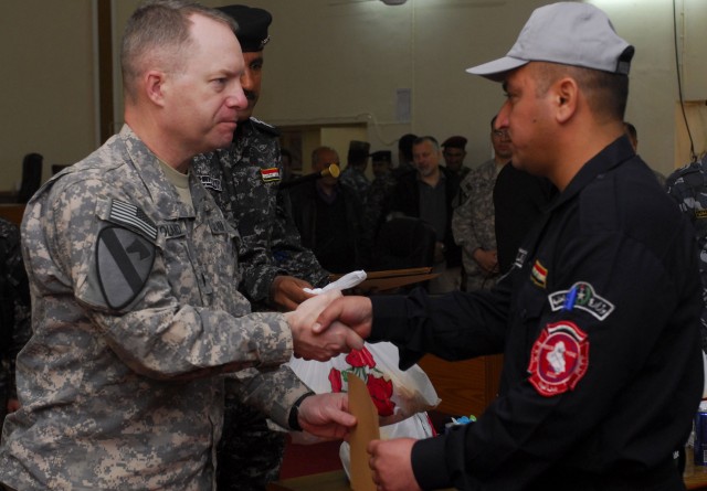 CONTINGENCY OPERATING SITE WARRIOR, Iraq - Lt. Col. Joseph Holland, commander of 2nd Battalion, 12th Cavalry Regiment, attached to 1st Advise and Assist Task Force, 1st Infantry Division, presents an Iraqi Police officer a certificate of...