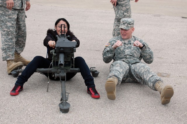 FORT HOOD, Texas-Sgt. Bret Lowery (right), a native of Springfield, Idaho, a multiple launch rocket system gunner for Battery C, 2nd Battalion, 20th Field Artillery Regiment, 41st Fires Brigade, demonstrates to Viviana Vaquera, a senior at A.J....